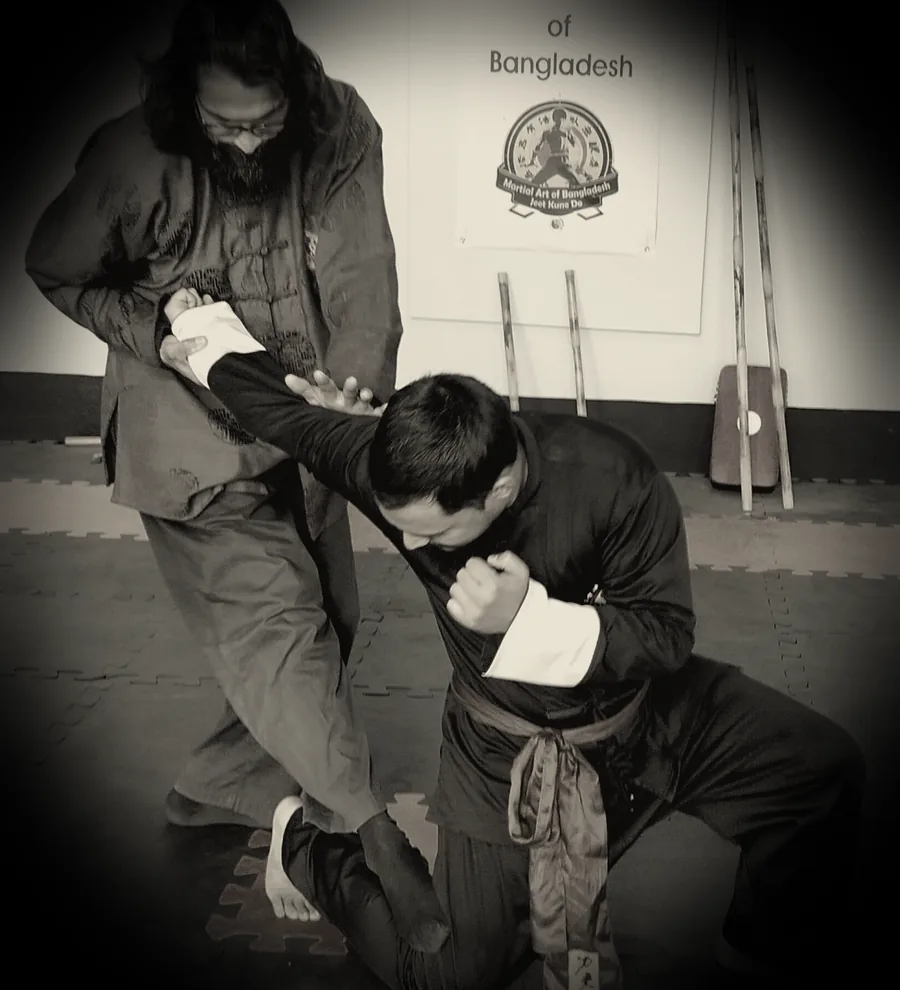 JKDBD instructor guiding a student through a close-range technique in Dhaka