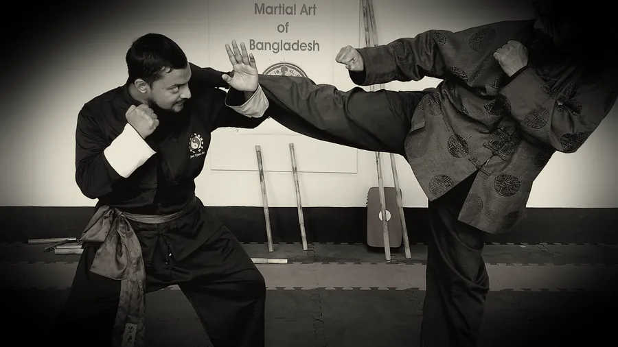 JKDBD lead instructor throwing a kick while a student defends with a hand trap